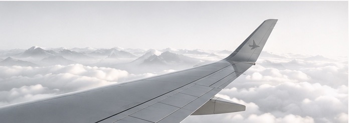 Aircraft wing above a calm layer of clouds